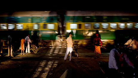 Just outside Noida at a railroad crossing, a bicyclist waits inches away from the train to continue his journey. (Kainaz Amaria for NPR)