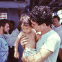 A USS Kirk crew member tends to a Vietnamese baby.