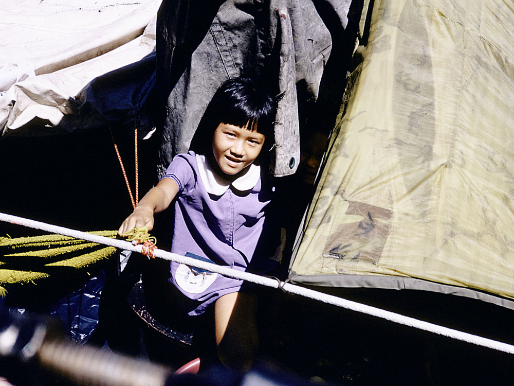 A Vietnamese refugee looks up at Kirk crew members.