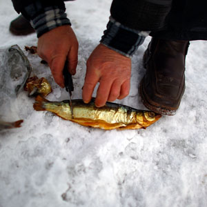 Bronnikov prepares cold-smoked omul on a snowbank. Omul is a type of whitefish found only in Lake Baikal, and is considered a delicacy throughout Russia. (David Gilkey/NPR)