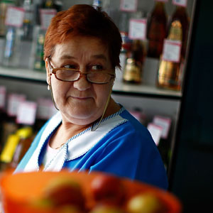 Tatiana Ilyinichna works behind the counter of a small grocery store. (David Gilkey/NPR)
