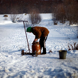 A man hauls water in old milk cans. Many homes in rural areas here do not have running water. (David Gilkey/NPR)