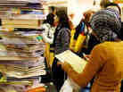Woman in front of a stack of books; credit: Sebastian Willnow / AFP / Getty Images