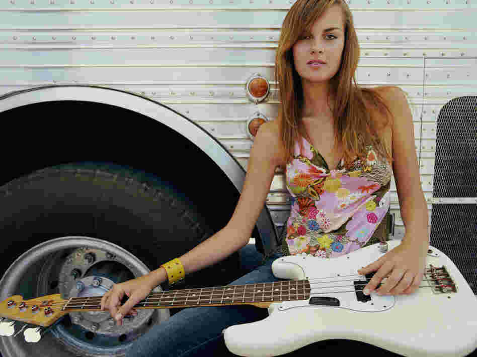 Bassist in front of a tour bus; credit: Peter Beavis / Getty Images
