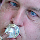 A man blows into a brass instrument A man blows into a brass instrument