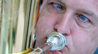 A man blows into a brass instrument A man blows into a brass instrument