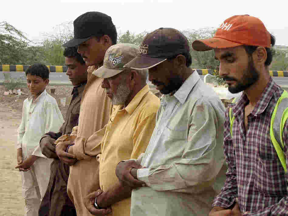 Gravediggers hold a short funeral service for a man found dead in the Karachi streets.
