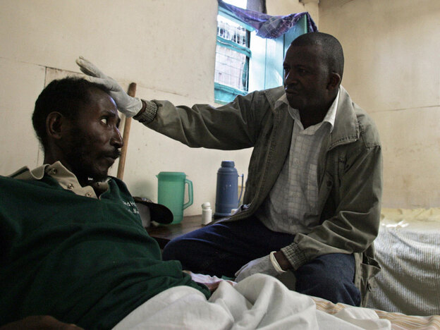 Charles Kibe, right, a volunteer who works with HIV/AIDS-infected people in Nairobi.