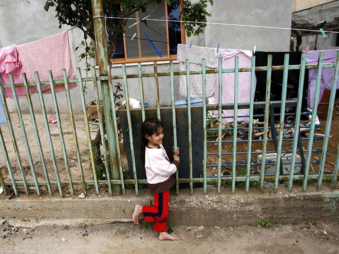 A barefoot girl stands outside her home in Ghajar, May 3, 2009.