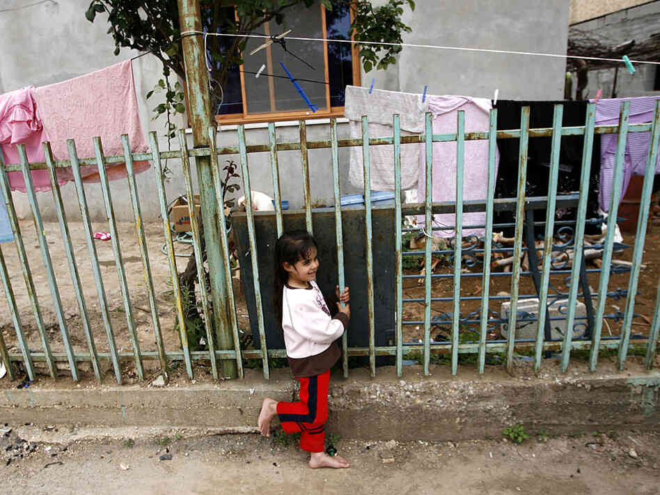 A barefoot girl stands outside her home in Ghajar, May 3, 2009.