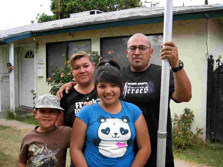 Leonard and Sylvia Contreras stand in the front yard of their former rental house in Fresno, Calif.