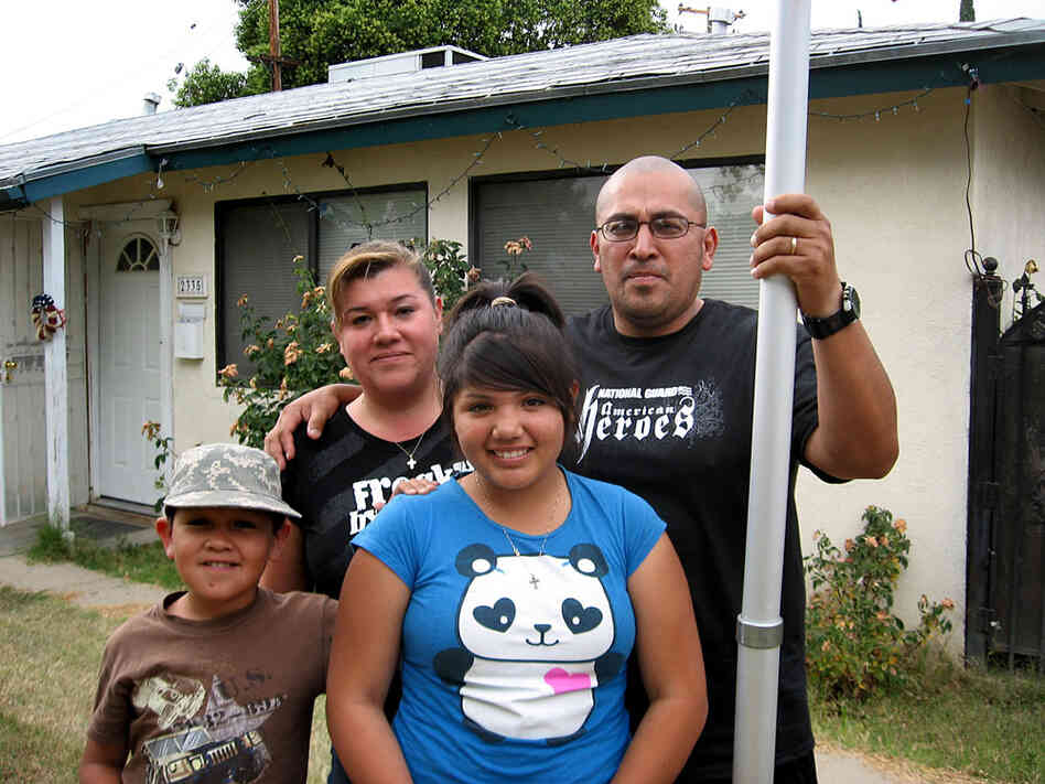 Leonard and Sylvia Contreras stand in the front yard of their former rental house in Fresno, Calif.