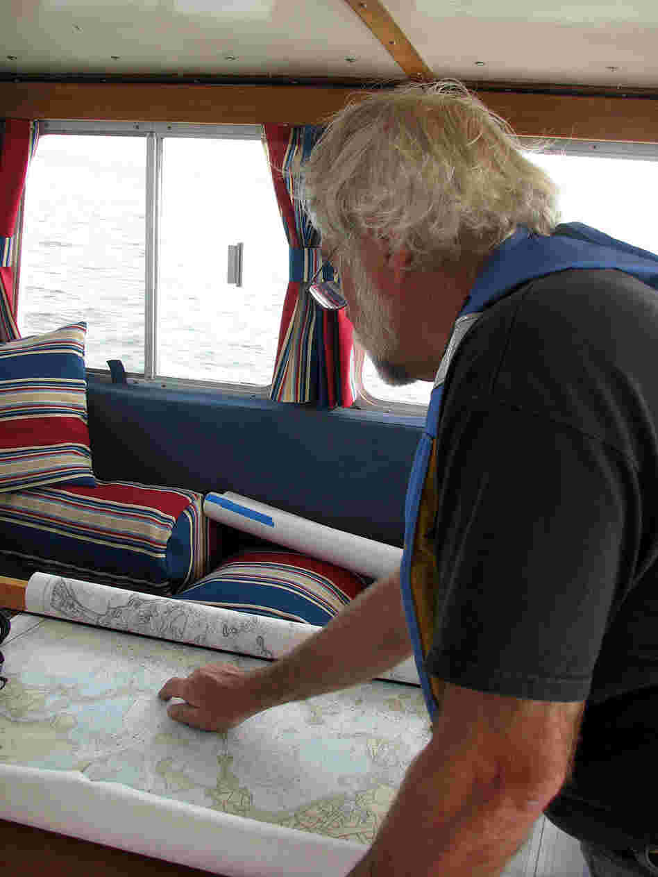 Captain John Williamson examines a chart of Massachusetts Bay.