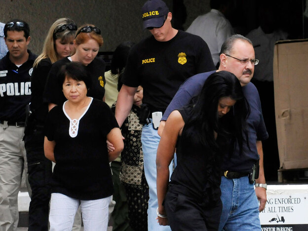 Federal agents escort suspects out of the FBI offices July 29, 2009 in Houston.