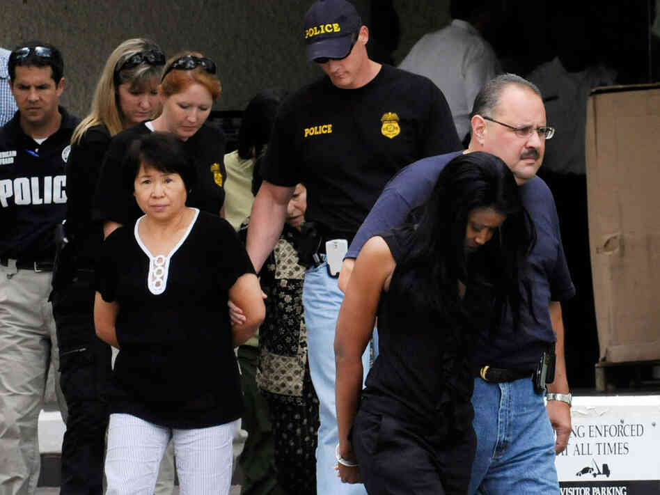 Federal agents escort suspects out of the FBI offices July 29, 2009 in Houston.