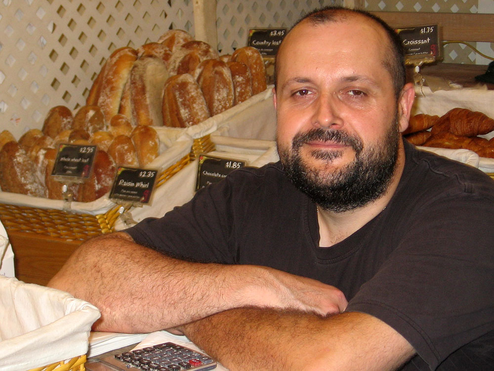 Baker Bertrand Houlier with the sweet treats and breads he sells at the Montgomery Farm Women's Cooperative Market in Bethesda, Md.