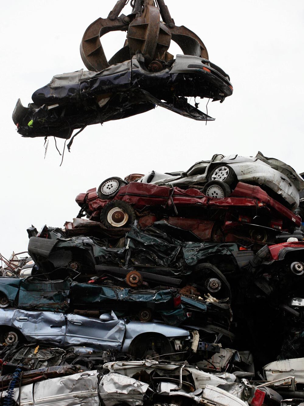 A car dangling over a wreckage yard. Mark Lennihan/AP