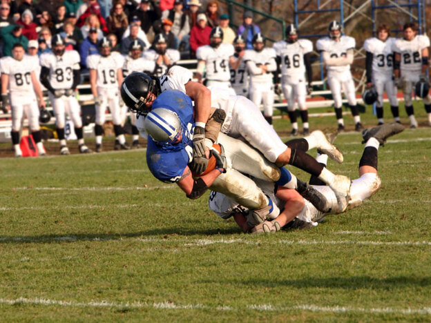 A high school football player is tackled.
