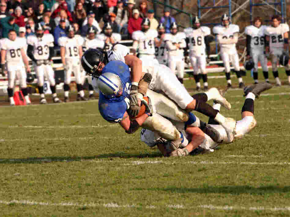 A high school football player is tackled.