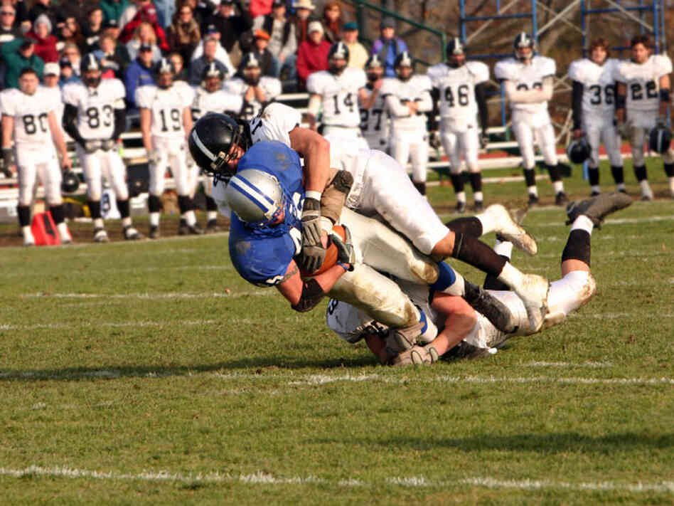A high school football player is tackled.