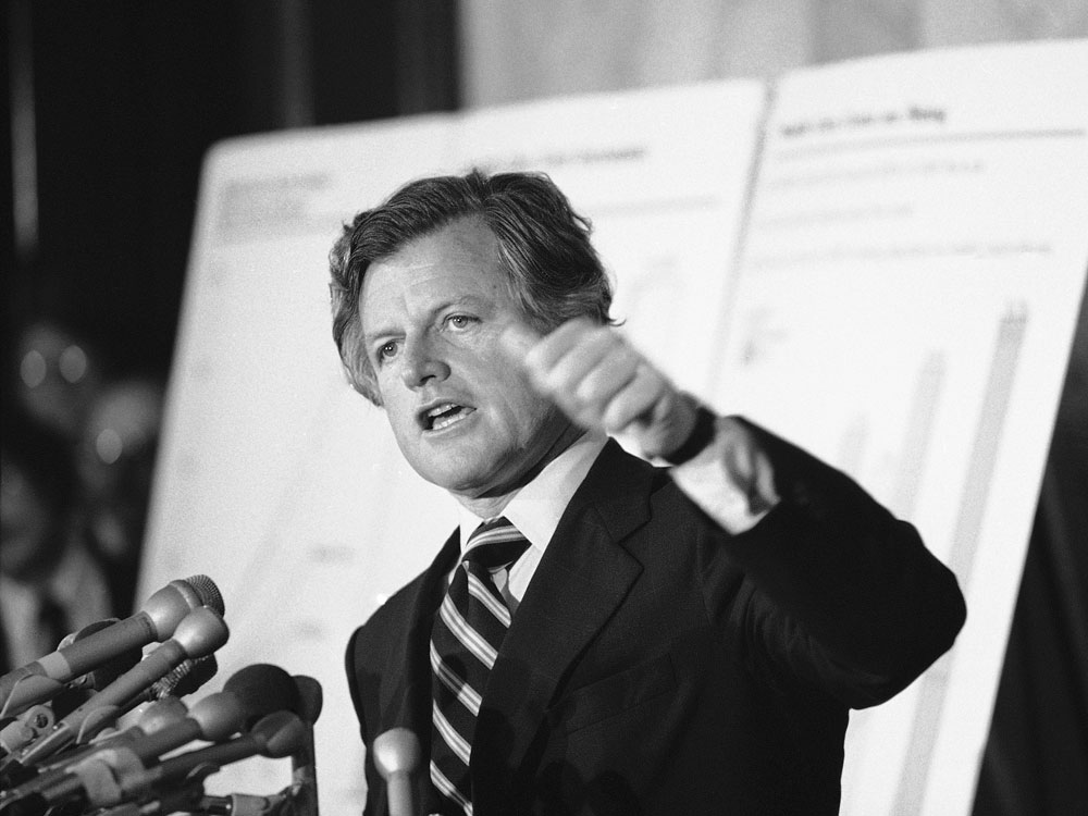 Sen. Edward Kennedy announced his proposal for a national health care plan at the Capitol on May 15, 1979. Behind him, large charts illustrate rising health costs in the U.S.