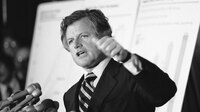 Sen. Edward Kennedy announced his proposal for a national health care plan at the Capitol on May 15, 1979. Behind him, large charts illustrate rising health costs in the U.S.