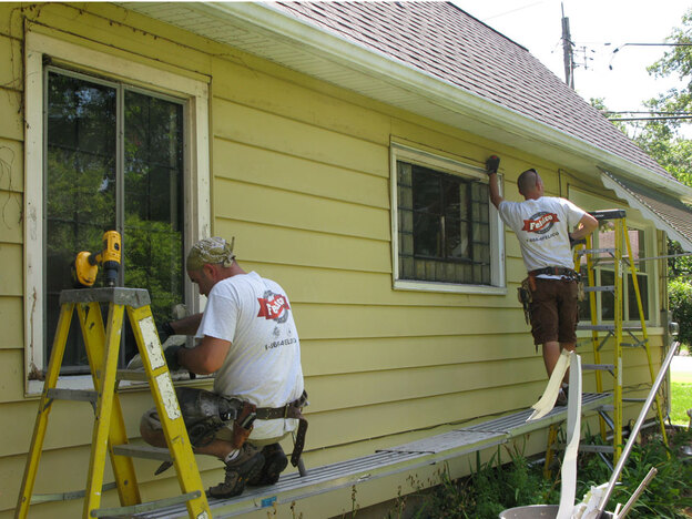 A work crew replaces old windows at a home in Illinois.