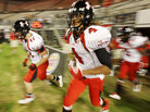 Football players enter a football field Football players enter a football field
