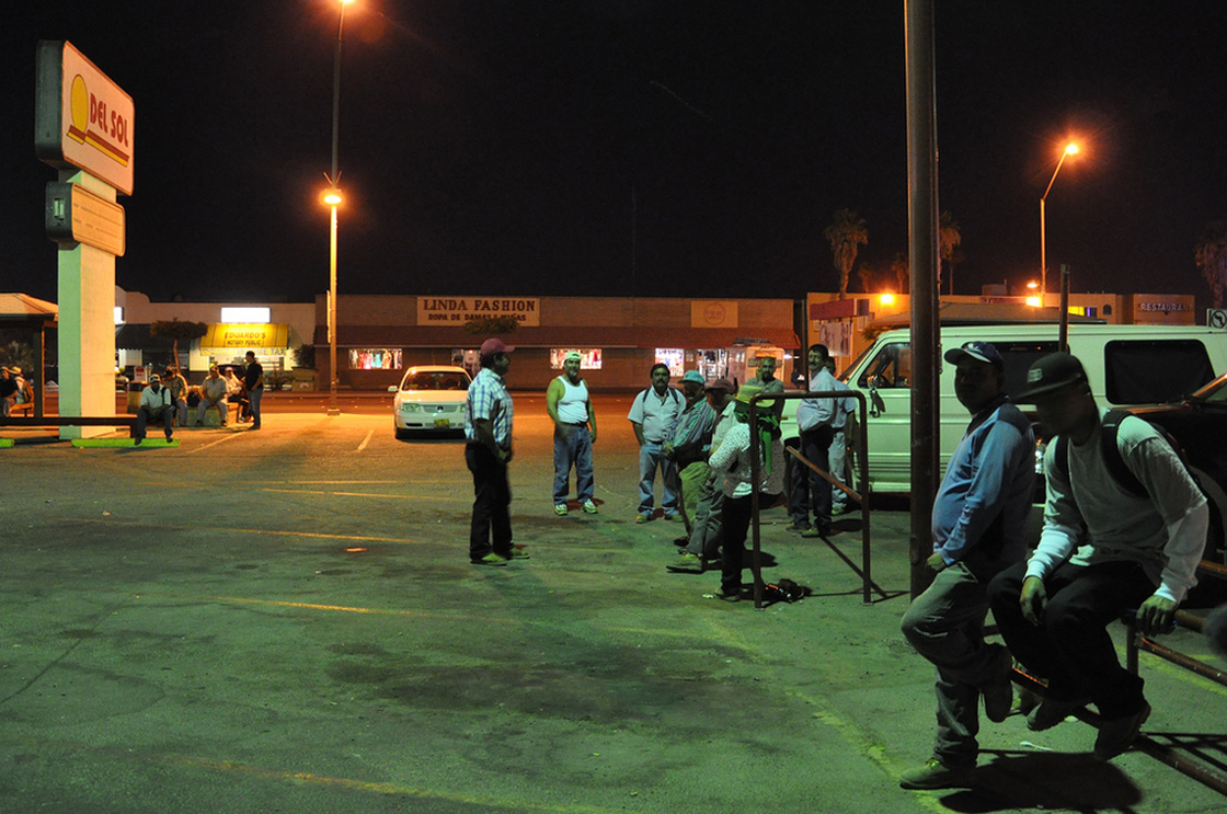 Farm laborers wait at 3 a.m. on Main Street. Jesse Shapins