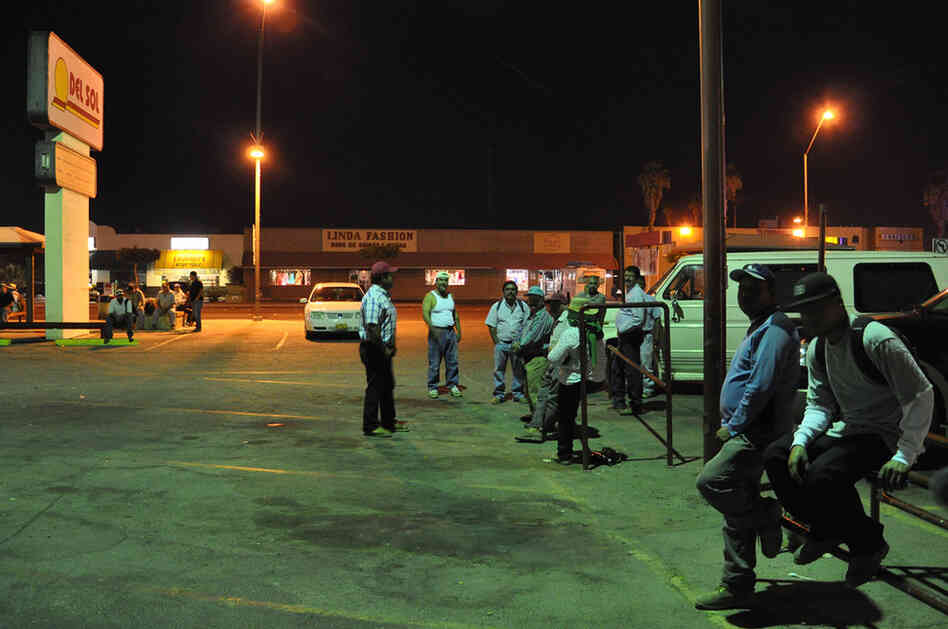 Farm laborers wait at 3 a.m. on Main Street. Jesse Shapins