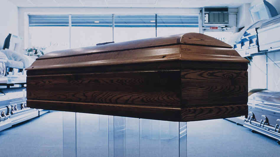 (Wide) A coffin on display in a showroom. (Wide) A coffin on display in a showroom.