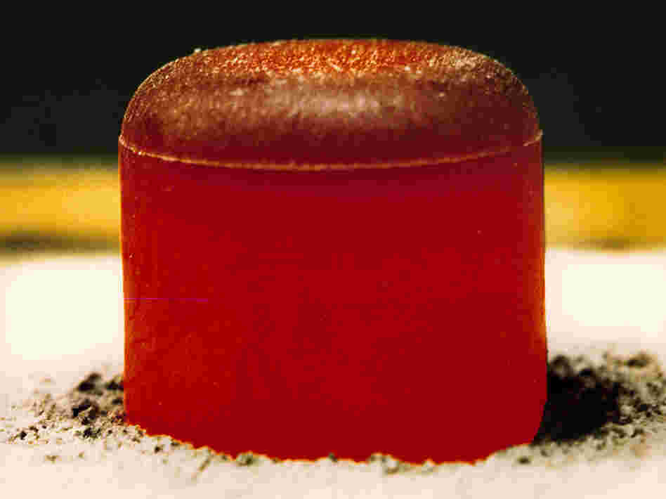 A pellet of plutonium-238 dioxide, glowing red.