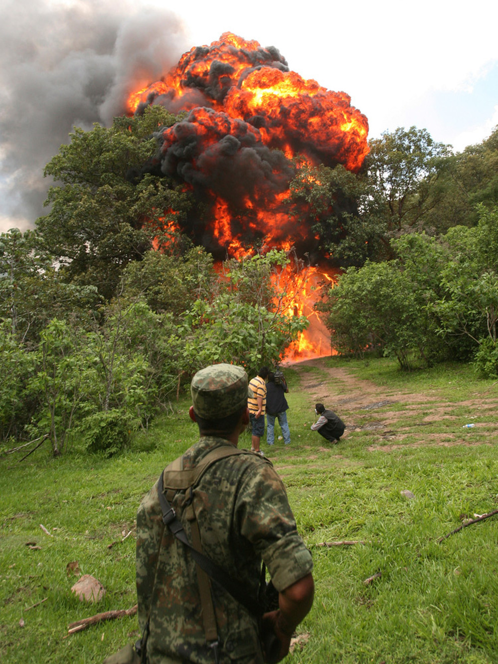 A soldier watches the burning of a clandestine methamphetamine laboratory.