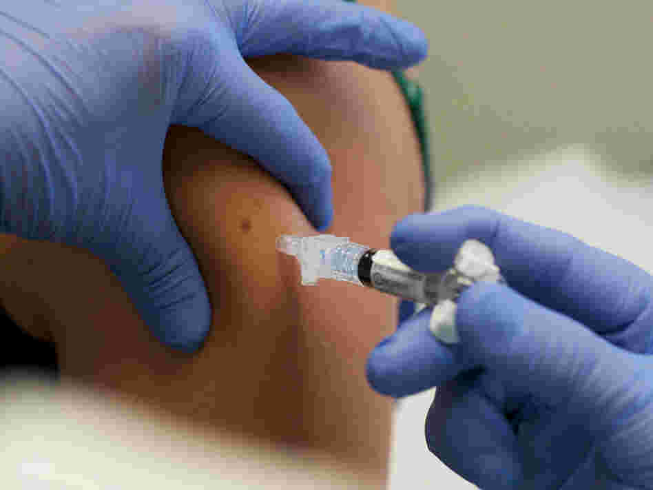 A woman is given a shot of the H1N1 vaccine.