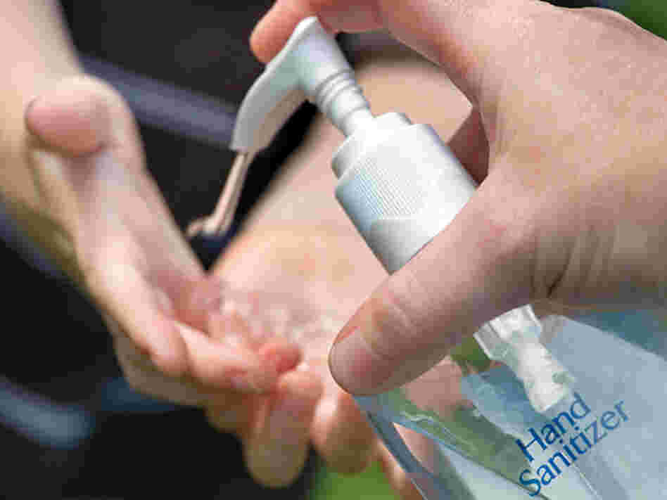 An adult squirts hand sanitizer into a child's hands.