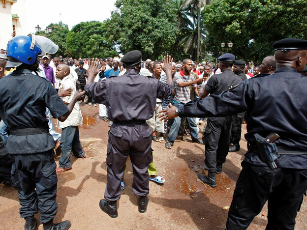 Police control the crowd as they react before looking for the bodies of family members and friends.