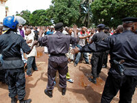 Police control the crowd as they react before looking for the bodies of family members and friends that were killed during a rally.