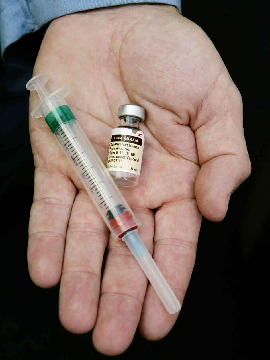 A man holds a vaccine against HPV in his outstretched palm. A man holds a vaccine against HPV in his outstretched palm.