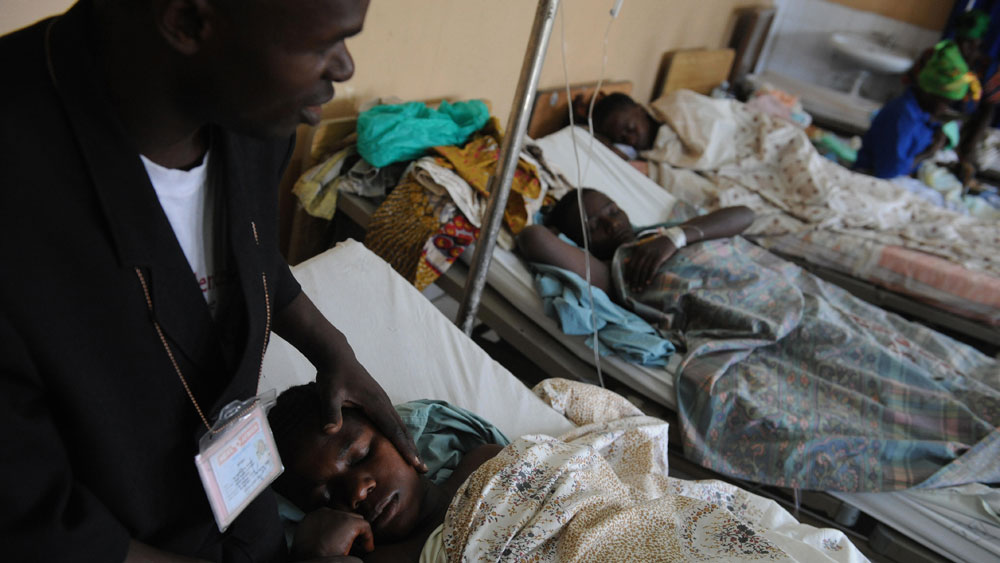 Father Samuel (left) holds the hand and the face of a rape victim as they pray at the Heal Africa clinic in Goma, Democratic Republic of Congo, on Aug. 11, just after the Congolese woman underwent surgery to repair physical damage suffered while being raped. Hundreds of thousands of women have been brutally raped in the country's nearly decade-long conflict.