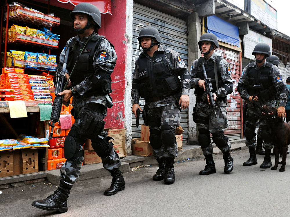 Police officers patrol the Jacarezinho slum in Rio de Janeiro on Monday. Just two weeks after the city won its bid to host the 2016 Olympic Games, an outburst of drug-related violence left two dozen dead.