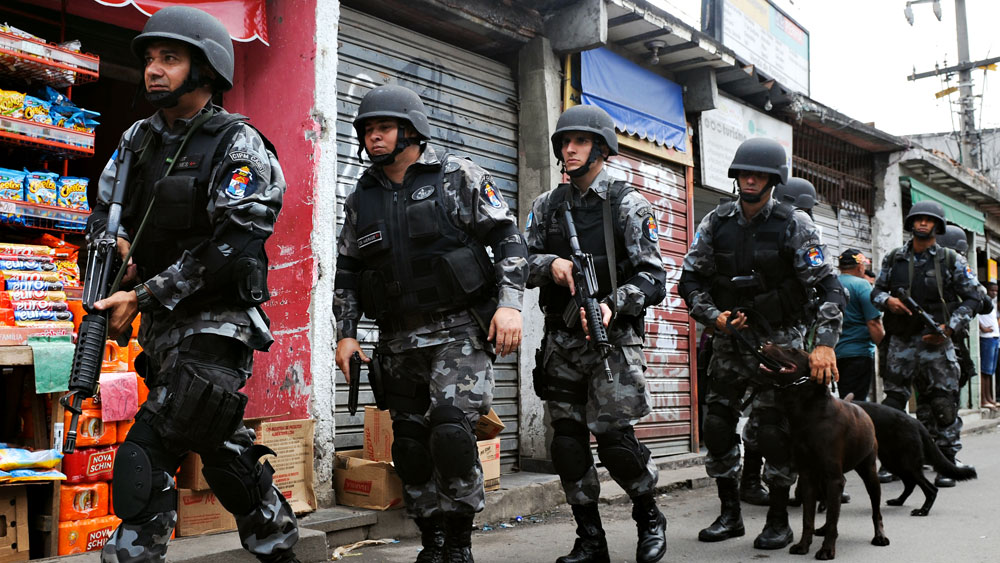 Police officers patrol the Jacarezinho slum in Rio de Janeiro on Monday. Just two weeks after the city won its bid to host the 2016 Olympic Games, an outburst of drug-related violence left two dozen dead.