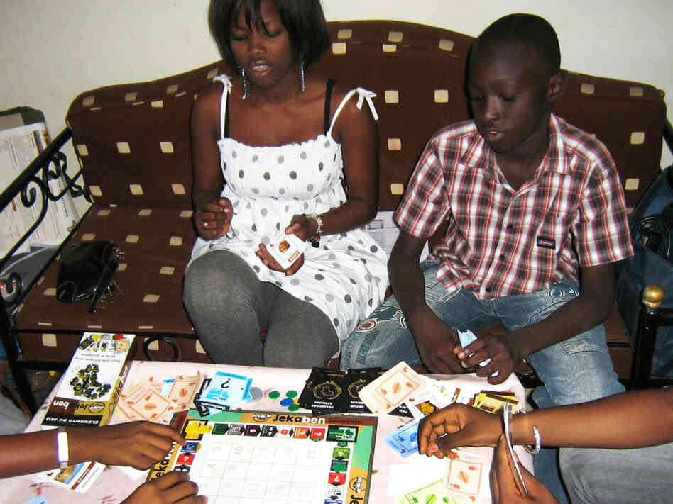 Aby Ba, from left, and Ousmane Mactar Ba play the board game Jekaben