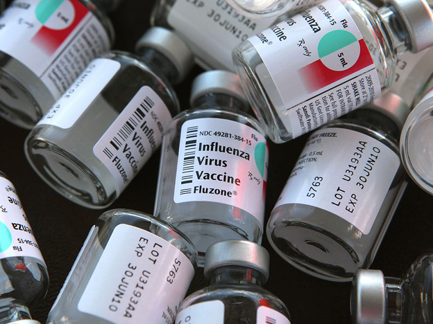 Empty bottles of flu vaccine on a table.