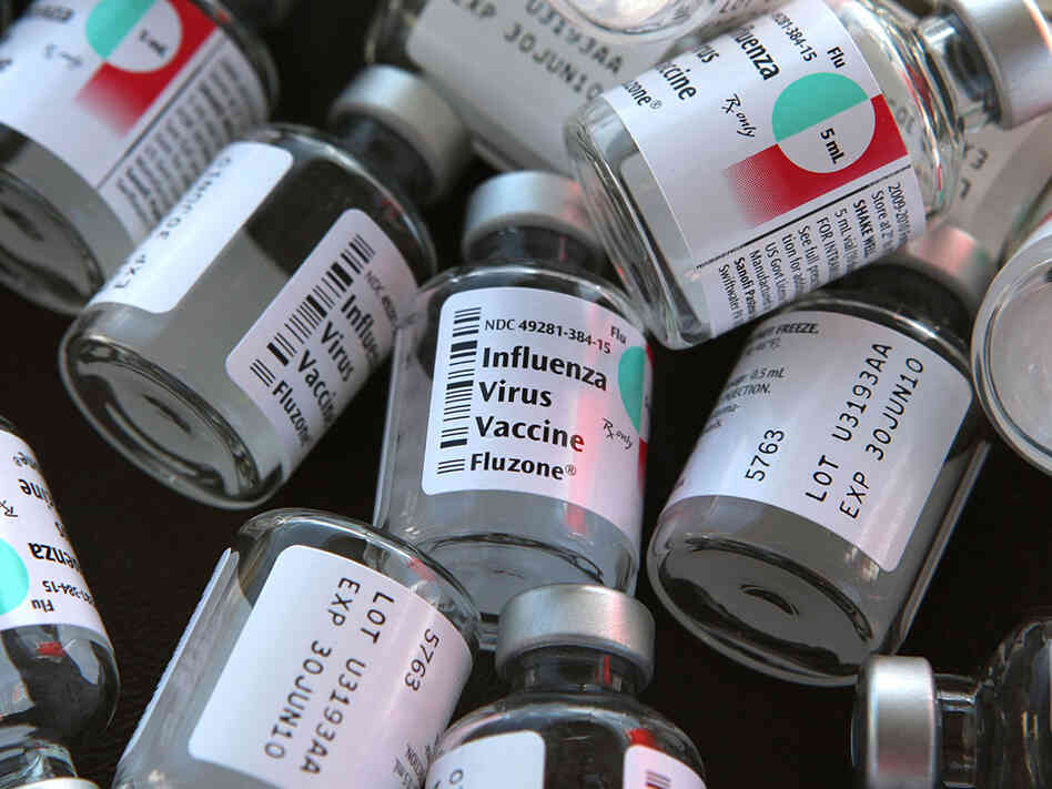Empty bottles of flu vaccine on a table.