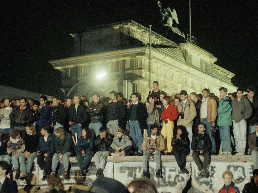 Hundreds of Berliners gather by the Brandenburg Gate to watch the dismantling of the Berlin Wall.