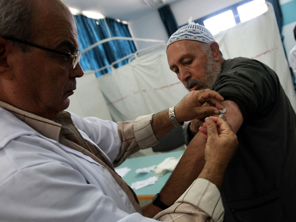 A Palestinian man who has registered to make the hajj gets a flu shot in Gaza City