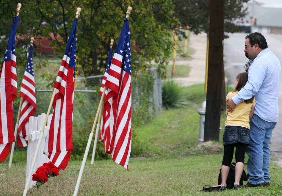Mourners stand in front of a memorial honoring Fort Hood shooting victims