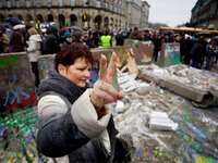 A Polish woman flashes the victory sign near the destroyed remains of a replica of the Berlin Wall in central Warsaw as a part of celebrations marking the 20th anniversary of the fall of the Berlin Wall, on Nov. 9, 2009.