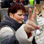 A Polish woman flashes the victory sign near a replica of the destroyed Berlin Wall in Warsaw