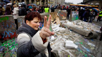 A Polish woman flashes the victory sign near the destroyed remains of a replica of the Berlin Wall in central Warsaw as a part of celebrations marking the 20th anniversary of the fall of the Berlin Wall, on Nov. 9, 2009.